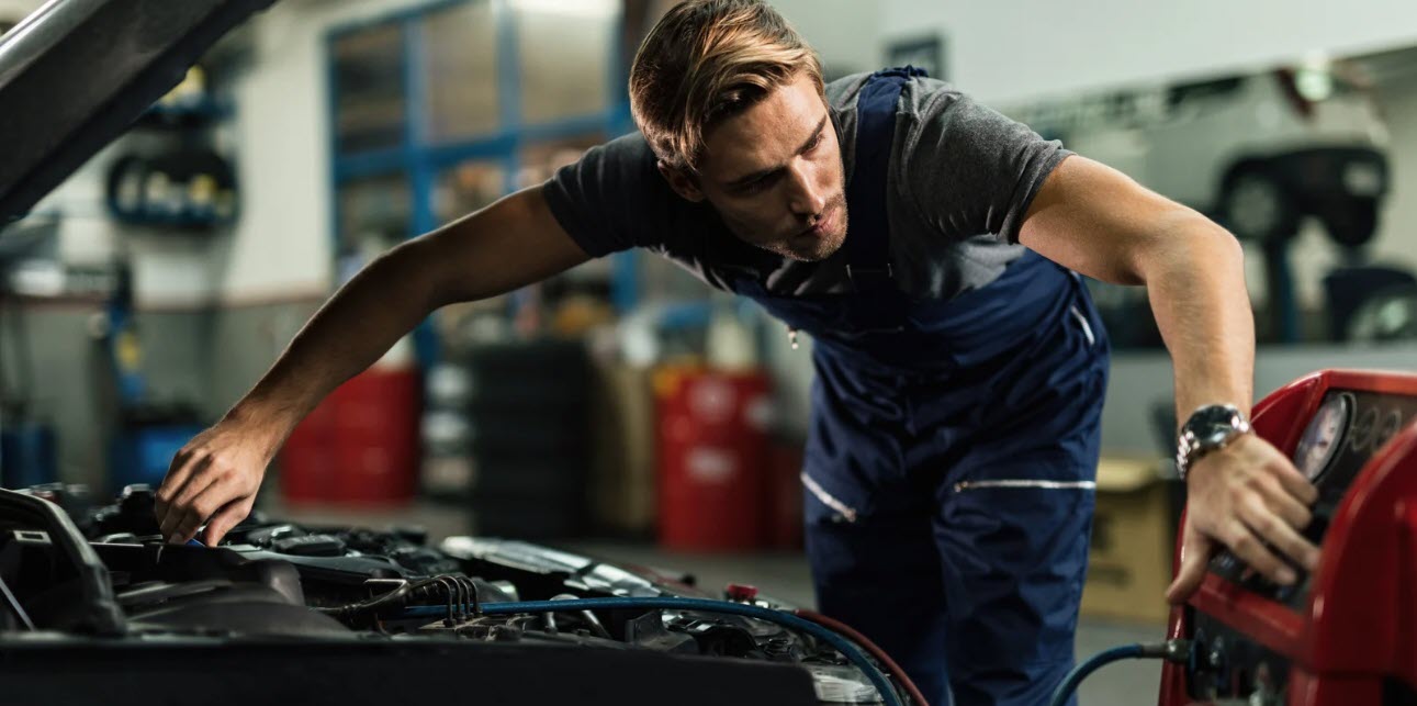 Auto-Mechaniker an der Arbeit am Motor des Autos