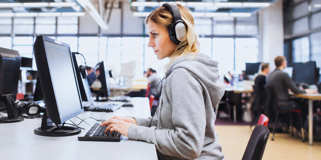 ICT-Weiterbildung aktuell: Mitarbeiterin vom dem Bildschirm am Programmieren
