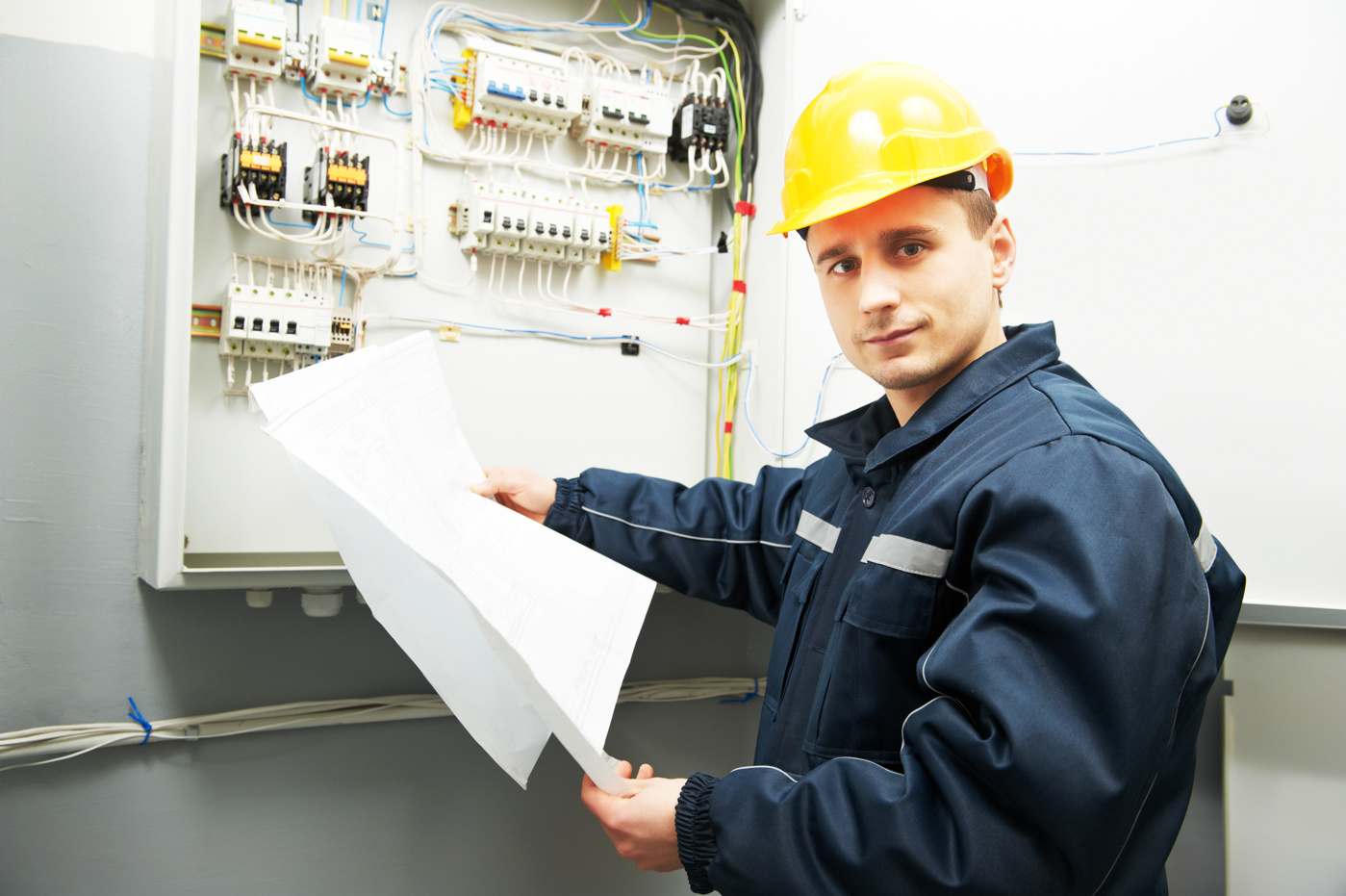 An electrical project manager for installation and safety with a federal certificate inspects an electrical installation in a building.