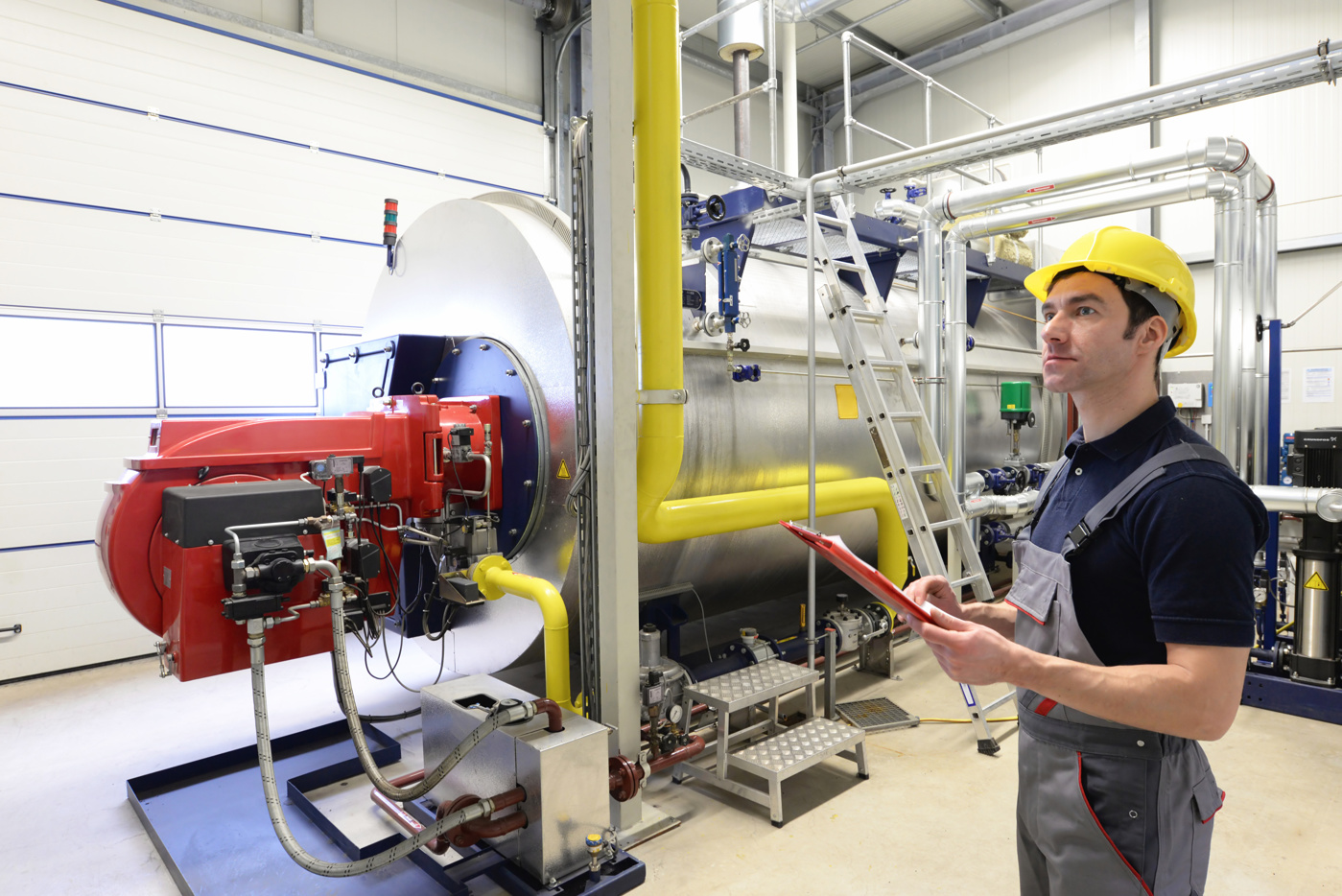 Uno specialista con laurea in ingegneria meccanica HF ispeziona una macchina industriale.