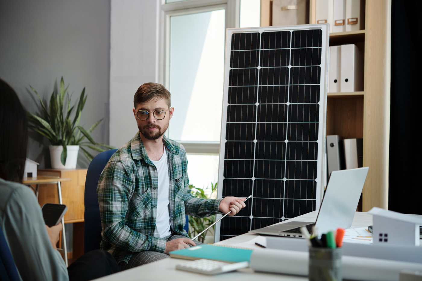 Ein Projektleiter Solarmontage mit eidg. Fachausweis zeigt einer potentiellen Kundin die Möglichkeiten für Ihr Haus auf.