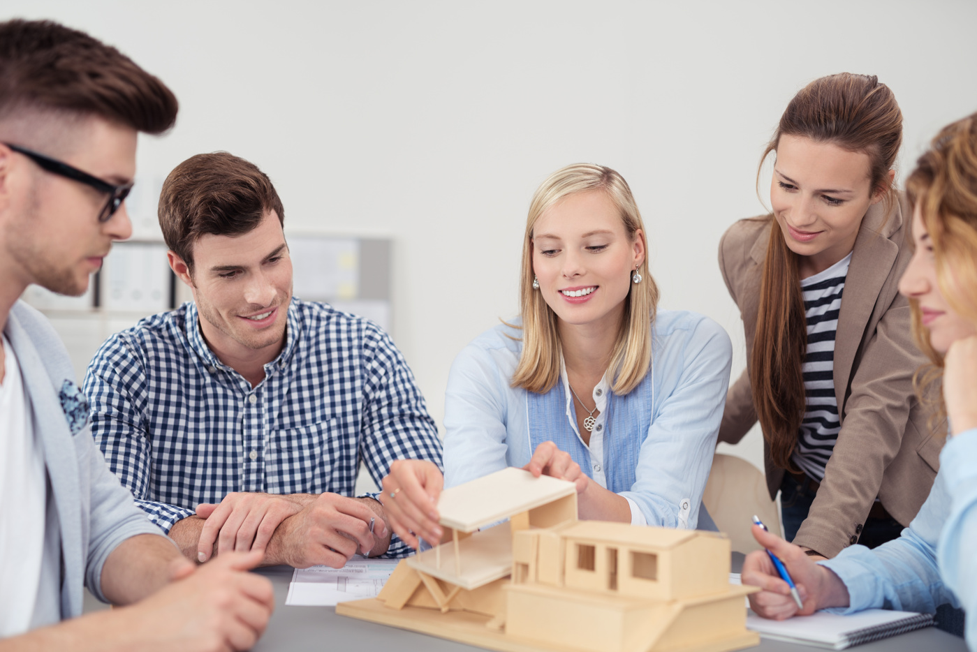 Eine Gruppe Architekturstudenten/-innen tauscht sich über das gemeinsame Projekt aus.